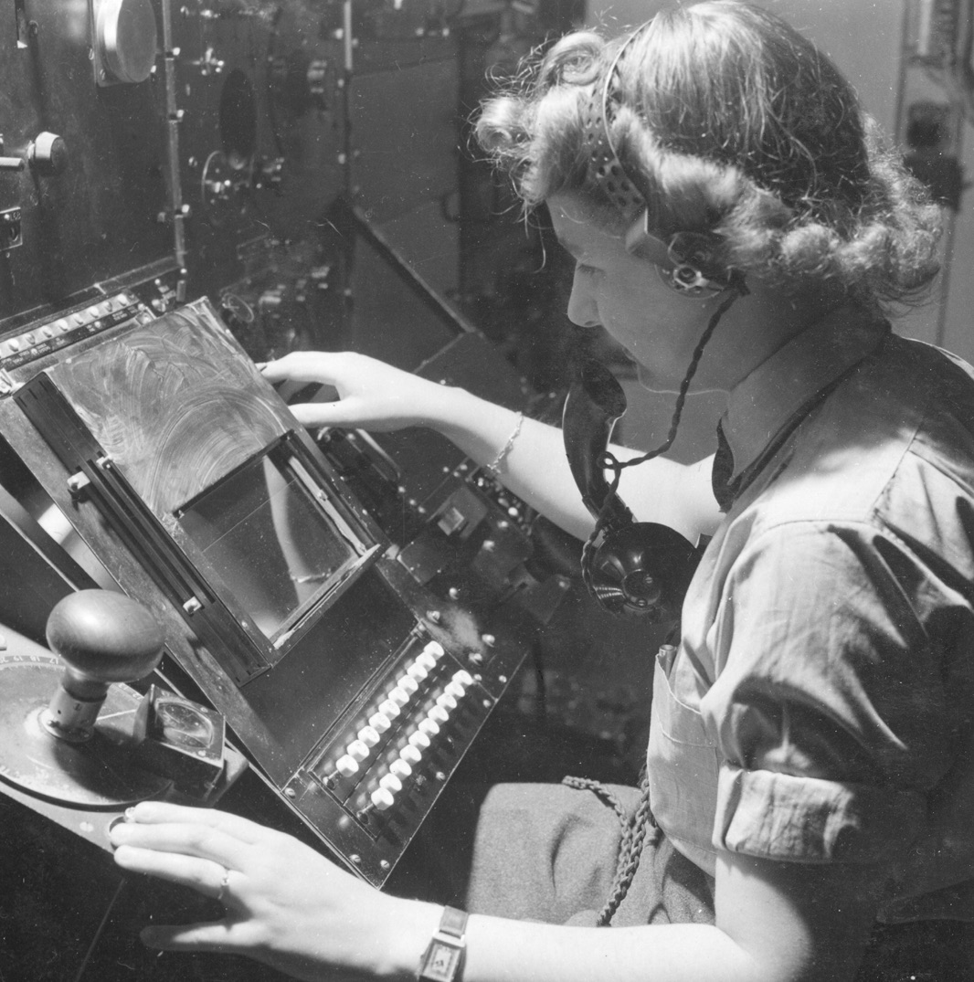 Black and white image of woman working with radio equipment.